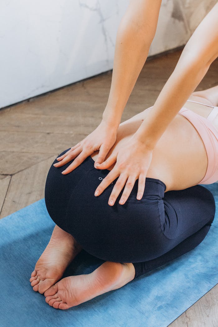 Woman performing yoga pose indoors on a mat focusing on flexibility and wellbeing.